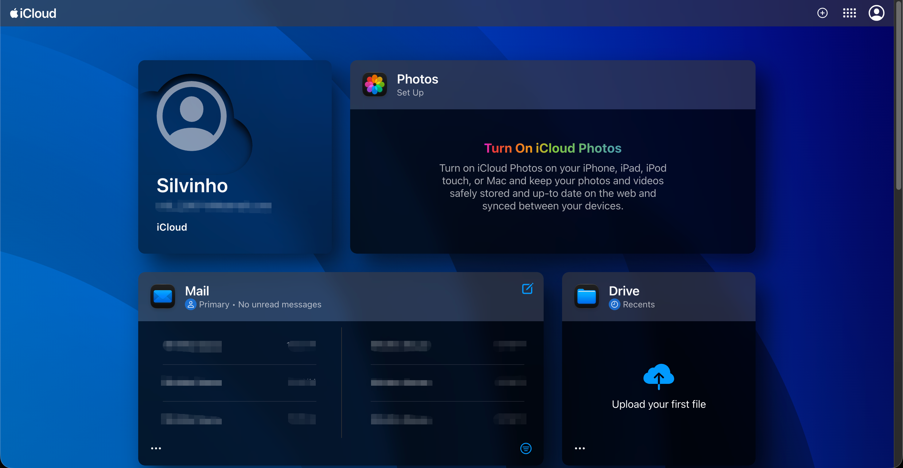 iCloud home page with an account tile on the left and Photos, Mail and Drive tiles